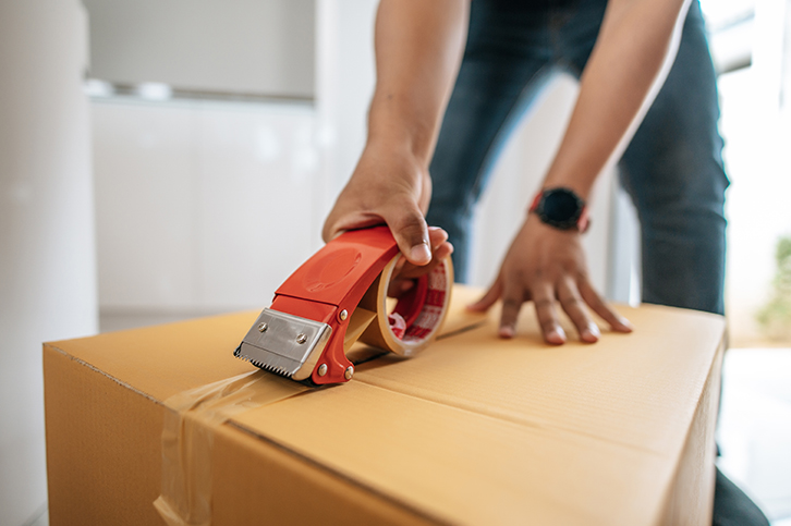 Close up hand of man use glue tape to close cardboard box, sealing big box for packing moving, new house concept, Selective focus	cardboard box,