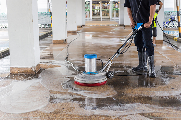 Asian worker cleaning sand wash exterior walkway